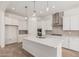 Bright kitchen with stainless steel appliances, island, white cabinets, and tile backsplash at 16494 W Creedance Blvd, Surprise, AZ 85387
