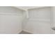 Spacious walk-in closet with neutral colored carpet and wooden clothing racks for ample storage at 16494 W Creedance Blvd, Surprise, AZ 85387