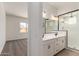 Bathroom featuring a double vanity sink, modern lighting, and a glass-enclosed shower at 16550 W Creedance Blvd, Surprise, AZ 85387