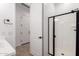 Bright bathroom with black shower door trim, door to outside and tile floors at 16550 W Creedance Blvd, Surprise, AZ 85387