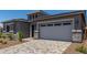 Two-car garage with a paver driveway, complemented by well-manicured landscaping and elegant exterior details at 16550 W Creedance Blvd, Surprise, AZ 85387