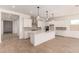 Modern kitchen with a large island, pendant lighting, and stainless steel range hood at 16550 W Creedance Blvd, Surprise, AZ 85387