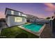 Inviting backyard featuring a sparkling pool, green turf, and string lights, perfect for outdoor entertaining at 16840 W Monroe St, Goodyear, AZ 85338