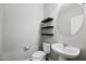 Powder room with modern floating shelves and stylish fixtures at 16840 W Monroe St, Goodyear, AZ 85338