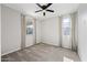A bright bedroom with neutral carpet, ceiling fan, and large windows providing natural light at 16840 W Monroe St, Goodyear, AZ 85338