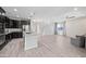 Modern kitchen with stainless steel appliances, dark cabinets, and a granite island, ideal for cooking at 16840 W Monroe St, Goodyear, AZ 85338