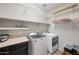 Well-equipped laundry room featuring modern appliances and ample counter space at 16840 W Monroe St, Goodyear, AZ 85338