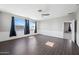 Spacious living room with wood floors, paneled walls, and large windows, adjacent bedroom view at 16840 W Monroe St, Goodyear, AZ 85338