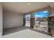 Covered patio with stone-clad pillars offers a stylish outdoor space with views of the neighborhood at 16840 W Monroe St, Goodyear, AZ 85338