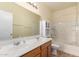 Bathroom featuring double sinks, vanity, and shower with tub, offering comfort and functionality at 16848 W Rimrock St, Surprise, AZ 85388