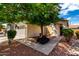 Well-kept house with desert landscaping, a large tree, and a two-car garage at 16848 W Rimrock St, Surprise, AZ 85388