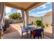 Covered patio with outdoor seating overlooking landscaped backyard at 16848 W Rimrock St, Surprise, AZ 85388