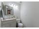 Well-lit half bathroom featuring a vanity with a modern faucet, complemented by a decorative mirror at 1718 S Longmore -- # 95, Mesa, AZ 85202