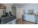 Kitchen view with stainless steel dishwasher, white cabinets, and view to living room with staircase at 1718 S Longmore -- # 95, Mesa, AZ 85202