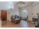 Bright living room with high ceilings, tile floors, fireplace, and large arched window with plant collection at 1718 S Longmore -- # 95, Mesa, AZ 85202