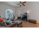 Cozy living room with a fireplace, tile floors, and large arched window for natural light at 1718 S Longmore -- # 95, Mesa, AZ 85202