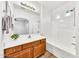 A very clean bathroom with a tub, shower, and a wood cabinet vanity with granite top at 1718 W Colter St # 195, Phoenix, AZ 85015