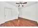 Bright bedroom featuring hardwood floors, a ceiling fan, white walls, and a closet with sliding doors at 1718 W Colter St # 195, Phoenix, AZ 85015