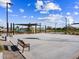 Community basketball court with benches and covered seating area, surrounded by lush landscaping and clear blue skies at 17715 W Ford St, Goodyear, AZ 85338