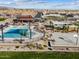 Aerial view of community pool and splash pad, with lounge seating, playground, and picnic areas at 17715 W Ford St, Goodyear, AZ 85338