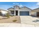 Charming single-story home featuring a gray garage door and low maintenance desert landscaping at 17836 W Mission Ln, Waddell, AZ 85355