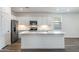 Modern kitchen with white cabinets, stainless steel appliances, and a large center island with sink at 17836 W Mission Ln, Waddell, AZ 85355