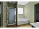 Relaxing bathroom features a tub, a standing shower and sleek fixtures at 20200 N Donithan Way, Maricopa, AZ 85138