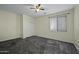 Bright and neutral bedroom with carpet floors, a ceiling fan, closet and a large window at 20200 N Donithan Way, Maricopa, AZ 85138