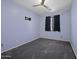 Bedroom featuring carpeted floors, ceiling fan, and window with black-out curtains at 20200 N Donithan Way, Maricopa, AZ 85138
