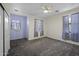 Carpeted bedroom with ceiling fan and a large window allowing for plenty of natural light at 20200 N Donithan Way, Maricopa, AZ 85138