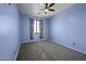 Carpeted bedroom with ceiling fan and a window letting in natural light at 20200 N Donithan Way, Maricopa, AZ 85138