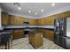 Well-equipped kitchen with stainless steel appliances, granite counters, wood cabinets, and a convenient center island at 20200 N Donithan Way, Maricopa, AZ 85138