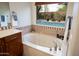 Bright bathroom features a large tub under a window overlooking the pool area at 2038 W Whisper Rock Trl, Phoenix, AZ 85085