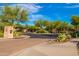 Gated community entrance with stone accents and mature desert landscaping at 2038 W Whisper Rock Trl, Phoenix, AZ 85085