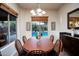 Bright dining area featuring views of the pool through large windows and stylish furnishings at 2038 W Whisper Rock Trl, Phoenix, AZ 85085