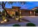Contemporary home with desert landscaping, a three car garage and warm exterior lighting at 2038 W Whisper Rock Trl, Phoenix, AZ 85085