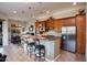Spacious kitchen features wooden cabinetry, stainless steel appliances, and a breakfast bar with seating at 2038 W Whisper Rock Trl, Phoenix, AZ 85085