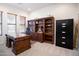 Well-lit home office with a large desk, a built-in bookcase, and neutral carpet at 2038 W Whisper Rock Trl, Phoenix, AZ 85085