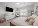 Bright bedroom with a cozy bed, a large television, and a dresser with decorative accents for a comfortable retreat at 22728 E Camacho Rd, Queen Creek, AZ 85142