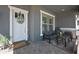 Cozy front porch with comfortable seating, a decorative wreath, and stylish outdoor decor at 22728 E Camacho Rd, Queen Creek, AZ 85142