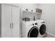 Well-organized laundry room with modern washer, dryer, and ample storage space at 22728 E Camacho Rd, Queen Creek, AZ 85142