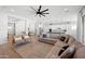 Spacious open floor plan featuring a sectional sofa, hardwood floors, and seamless flow to other living spaces at 22728 E Camacho Rd, Queen Creek, AZ 85142