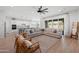 Bright living room with hardwood floors, a large sectional sofa, and a view into the kitchen and backyard at 22728 E Camacho Rd, Queen Creek, AZ 85142