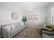 Comfortable living room with a gray sofa, accent chairs, and modern lighting fixtures at 22728 E Camacho Rd, Queen Creek, AZ 85142