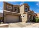 Tan two-story home featuring a two-car garage, tiled roof, and manicured front yard at 2721 E Schiliro Cir, Phoenix, AZ 85032
