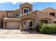 Inviting tan two-story home featuring a two-car garage, tiled roof, and well-manicured front yard with green shrubs at 2721 E Schiliro Cir, Phoenix, AZ 85032