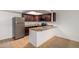 Galley kitchen with tile floors, granite countertops, stainless steel refrigerator, and dark wood cabinets at 3601 W Tierra Buena Ln # 168, Phoenix, AZ 85053