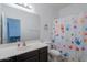 Bright bathroom with a modern vanity, large mirror, and colorful handprint shower curtain at 3901 E Packard Dr, Gilbert, AZ 85298