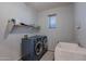 Spacious laundry room with modern washer and dryer, utility sink, and ample shelving at 3901 E Packard Dr, Gilbert, AZ 85298