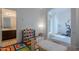 Well-lit playroom with organized toy storage, colorful rug, and access to an adjacent bathroom at 3901 E Packard Dr, Gilbert, AZ 85298